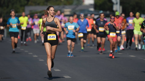 An endurance athlete running in a Half Marathon, surrounded by other runners.