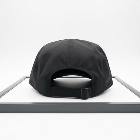 Black cap on a white surface with a metallic background