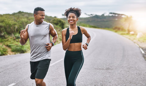 A couple beginner runners, navigate a scenic trail while smiling.