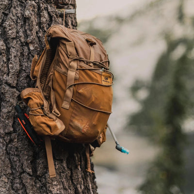 Orange Mud Adventure Pack hanging on a tree