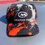 Orange_Mud_Splatter_Performance_Hat_on_a_car