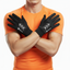 Person wearing black gloves with a brand logo, standing against an orange shirt background