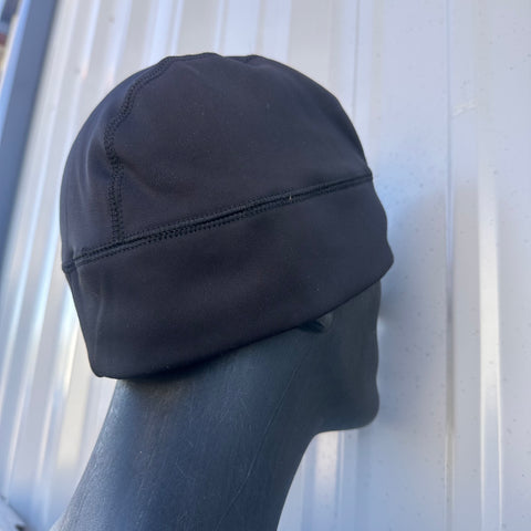 Black beanie on a mannequin head against a meatal background