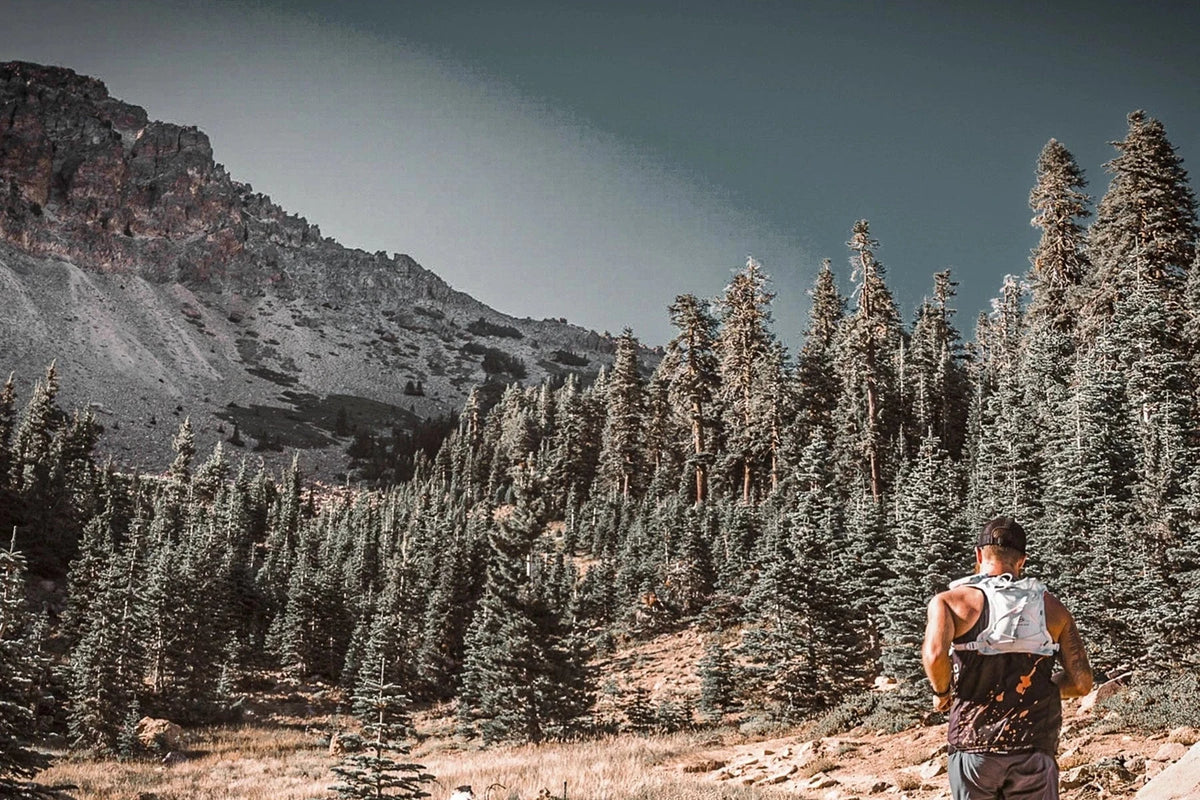 Runner wearing an Orange Mud Gear Vest on a mountain trail